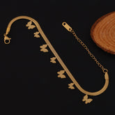 Gold bracelet with butterfly charms on a dark background