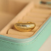 Gold ring in a jewelry box with a soft focus background