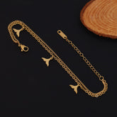 Gold chain with whale tail charms on a dark background