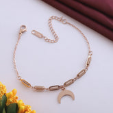 Rose gold bracelet with a moon charm on a light background