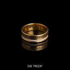 Gold ring with decorative design and small stones on a black background, branded 'Die Treza'.