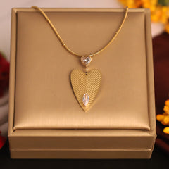 Gold necklace with a heart-shaped pendant on a gold box