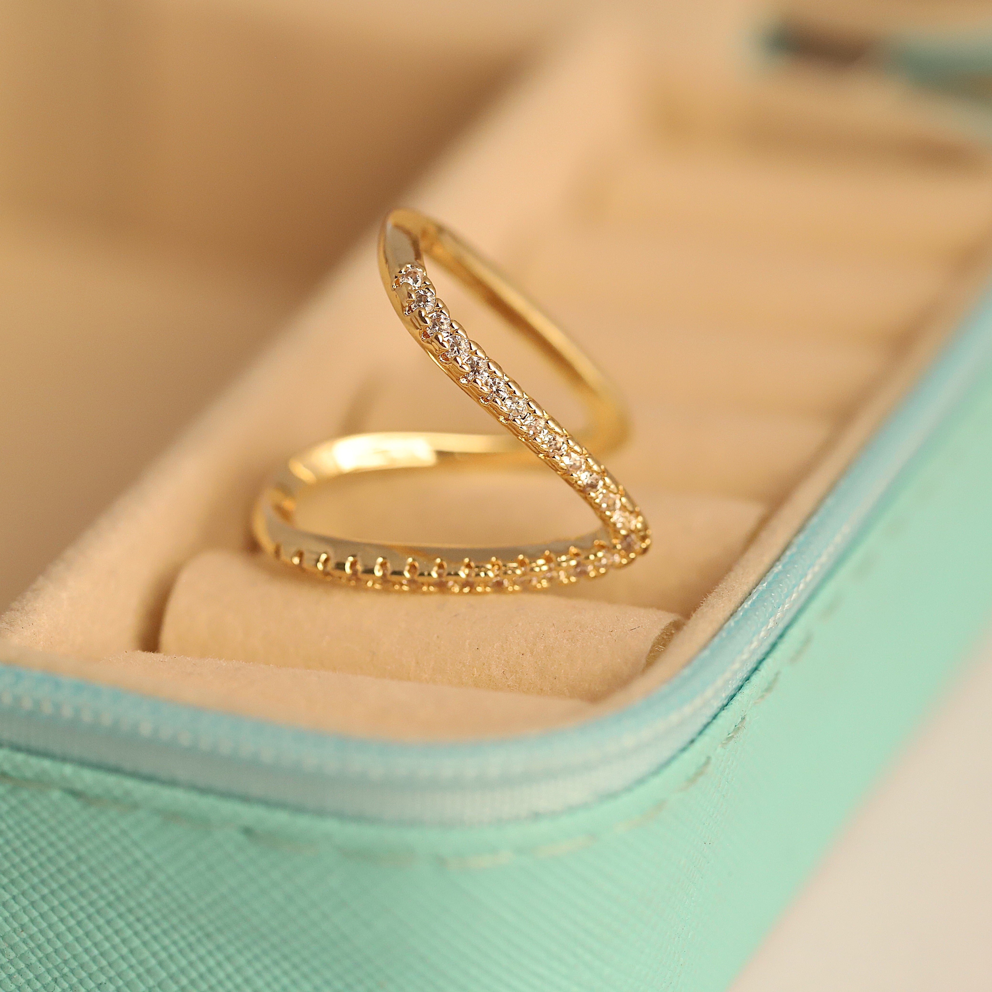 Gold ring with diamond accents on a light green cushion