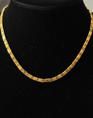 Gold necklace on a black velvet stand